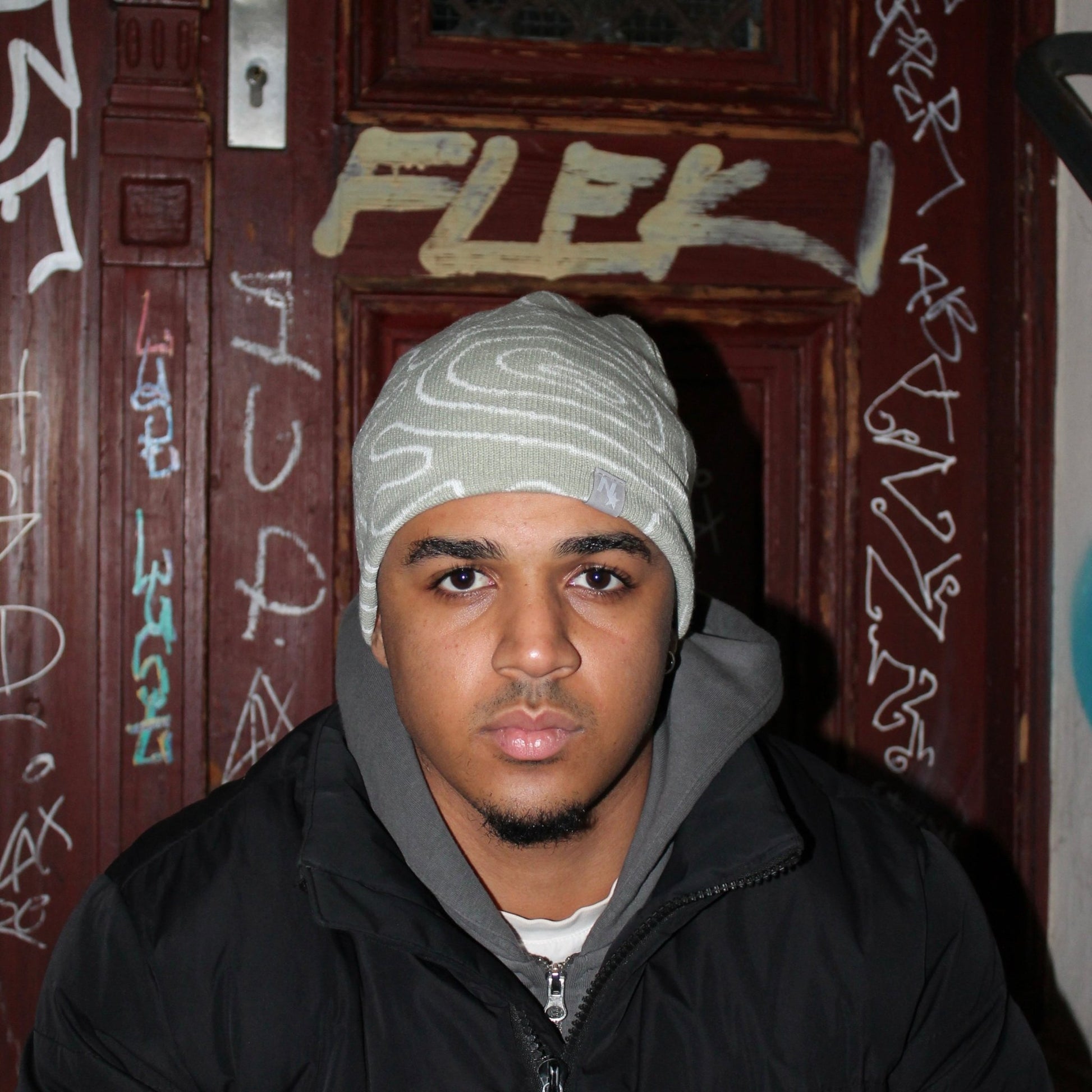 Model wearing the mint green NAIMS beanie with embroidered geographical map pattern – a stylish knit cap for streetwear and casual fashion.